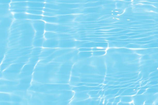 istock Blue water with ripples on the surface. Defocus blurred transparent blue colored clear calm water surface texture with splashes and bubbles. Water waves with shining pattern texture background. 1600413496