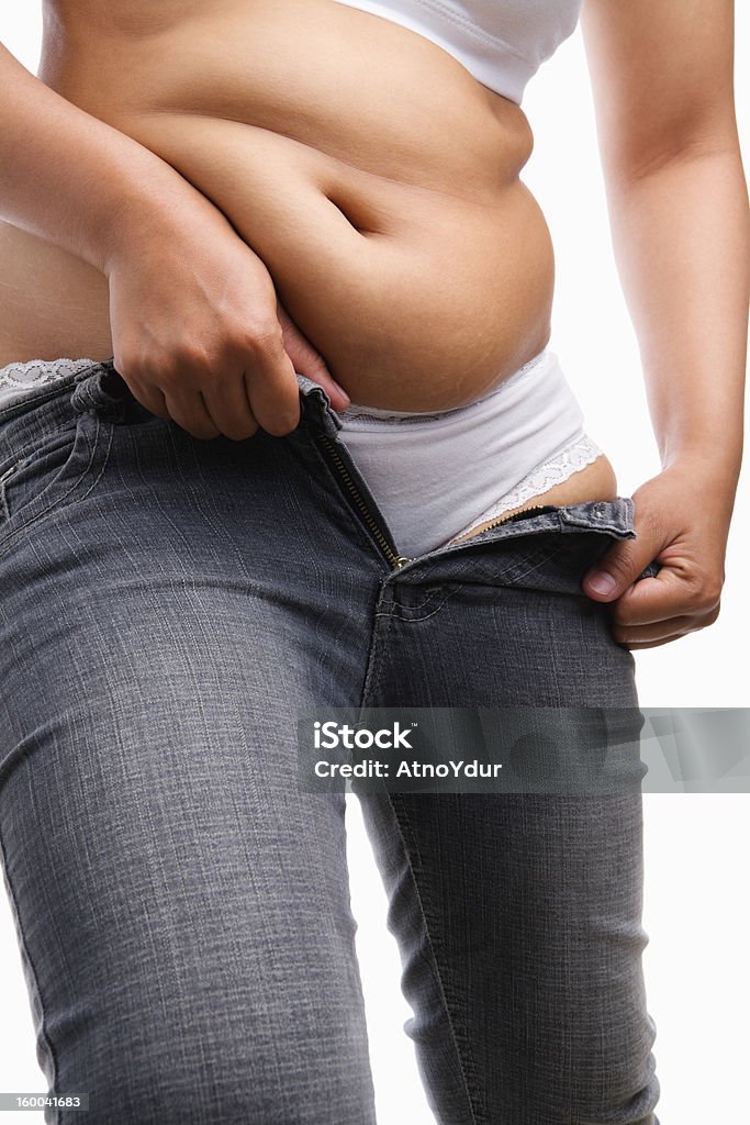 Overweight woman trying to wear tight jeans Overweight woman trying to wear tight jeans, a concept for obesity issue Jeans Stock Photo