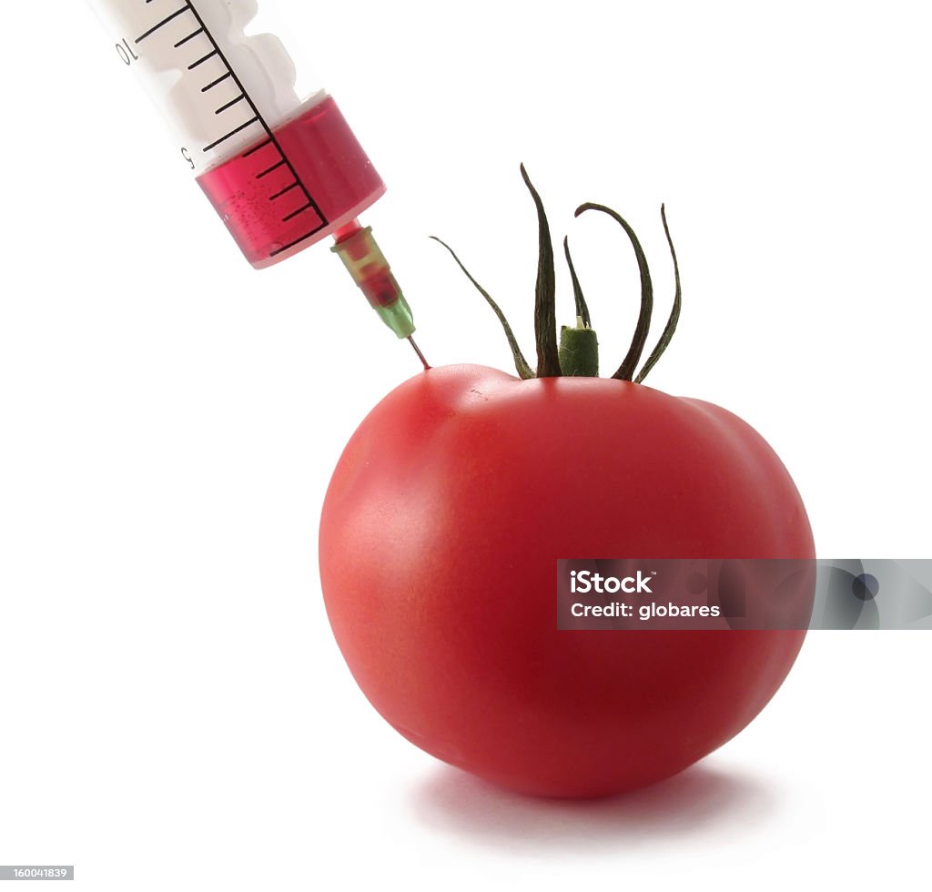 Photo of a syringe injecting a tomato Tomato with syringe put in Biotechnology Stock Photo