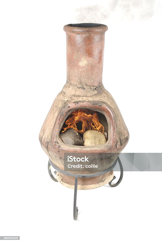 clay chiminea lit clay open fire with smoke on white background Brazier Stock Photo