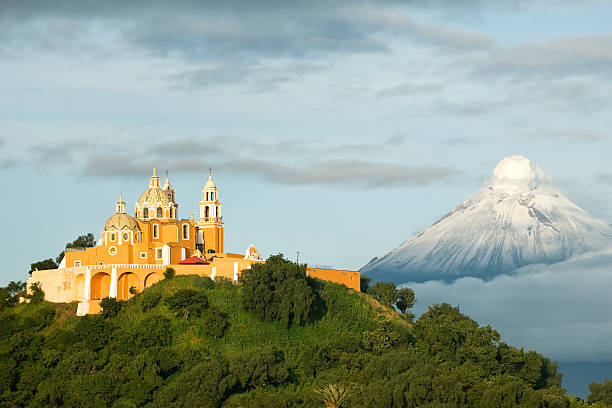 Popocatepetl - Smoking mountain View of Popocatepetl volcano, with the church of Nuestra Señora de los Remedios at the front. City of Cholula, Mexico. active volcano photos stock pictures, royalty-free photos & images