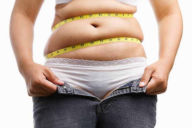 istock Overweight woman holding her unzip jeans 160043681
