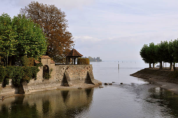 park with trees and stone wall at the lake of constance in autumn