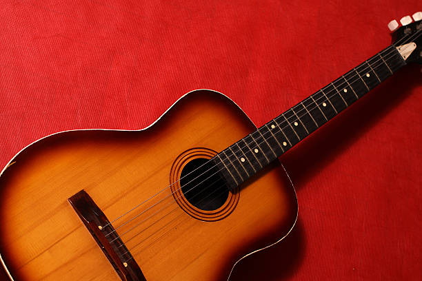 istock Acoustic Guitar Isolated On Red Wall 160043979