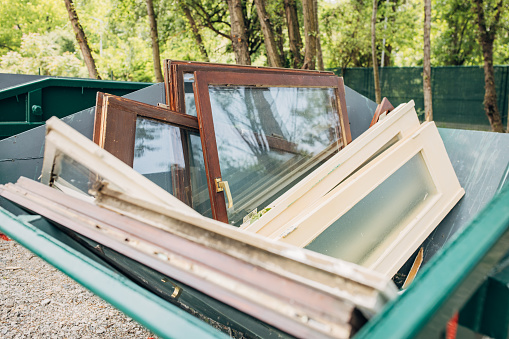 Old Windows in dumpster ready to recycle