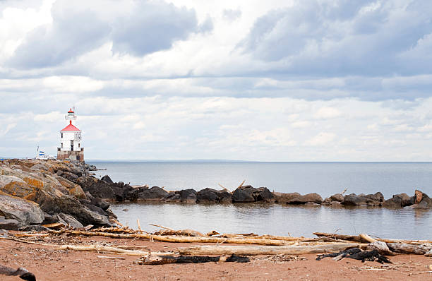 istock Lighthouse at end of rocky pier 160045196