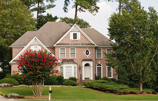 Traditional Brick Home with Blooming Crepe Myrtle stock photo