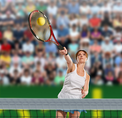 playing woman tennis and hitting the ball, background are with court and fans with tennis net on front