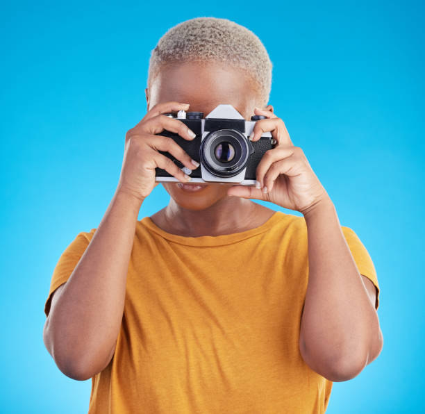 photographe femme, appareil photo rétro et studio pour travail journaliste, art ou photoshoot par fond bleu. fille africaine, objectif et technologie pour la créativité, la production ou la création de contenu pour le magazine paparazzi - photographer women retro revival camera photos et images de collection