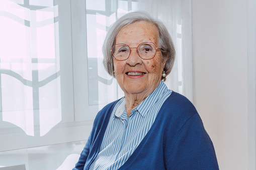 Portrait of a senior Latin American woman feeling strong and smiling at her nursing home while looking at the camera smiling