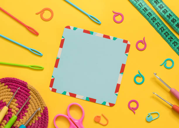 istock Empty blue card with crochet tools, crochet coaster on a yellow background. Top view. Copy space. 1600463302