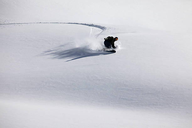 snow boarder cutting fresh tracks stock photo