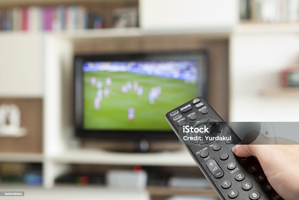サッカー観戦、テレビのリモコンを手に - サッカーのロイヤリティフリーストックフォト