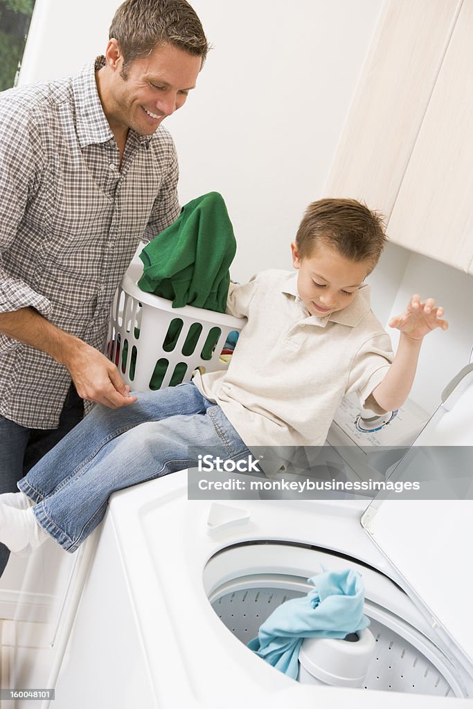 Padre e figlio facendo lavanderia - Foto stock royalty-free di Fare il bucato