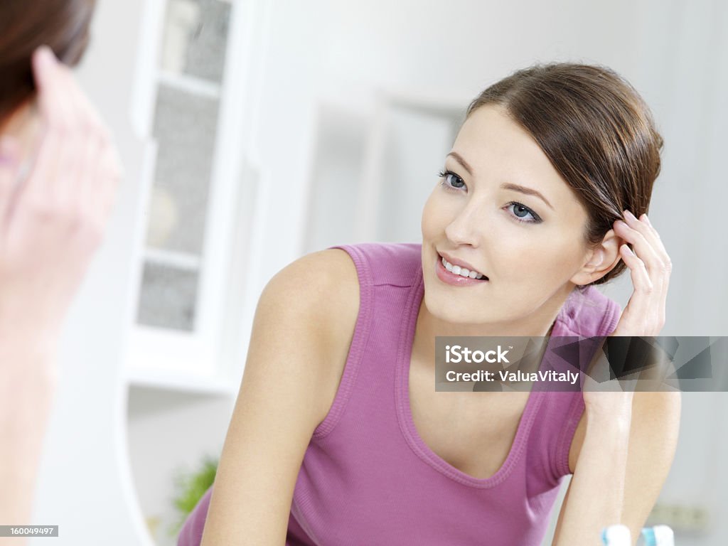 woman with clean fresh face stands about a mirror The beautiful young woman with clean fresh face stands about a mirror in a bathroom 20-29 Years Stock Photo