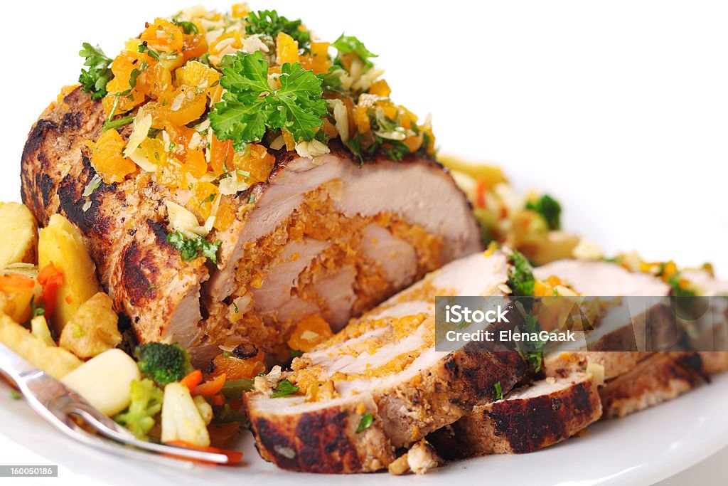 Stuffed pork roast with dried apricots and nuts. Stuffed pork roast with dried apricots and nuts on white background. Almond Stock Photo