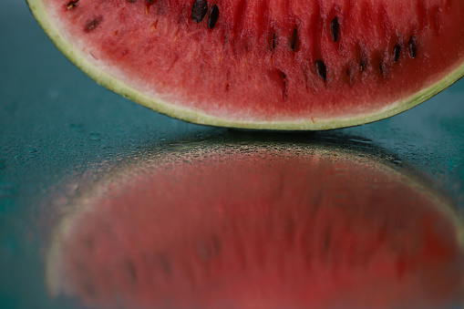 ripe juicy summer watermelon slices with water drops on a wet mirror surface. for advertising screensavers, leaflets, business cards, postcards, etc.