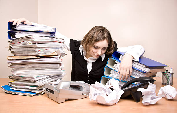 Young businesswoman with tons of documents stock photo