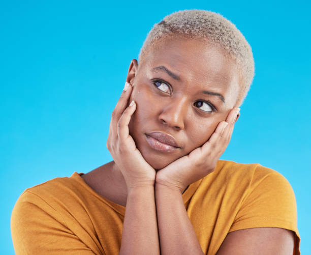 istock Thinking, sad and black woman with depression, decision or solution on a blue studio background. Person, alone or model with problem solving, thoughts or anxiety with mental health, unhappy or choice 1600508190
