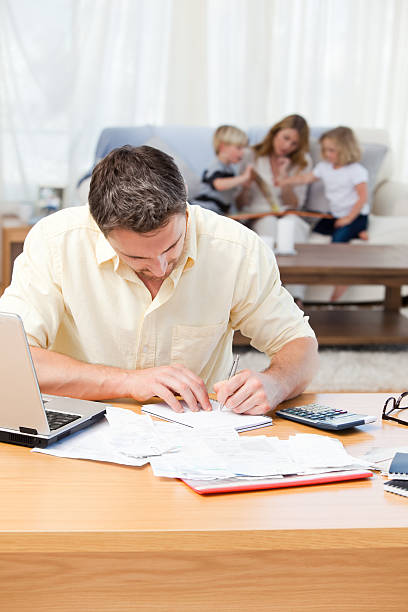 istock Man calculating the bills while his family reading 160051294