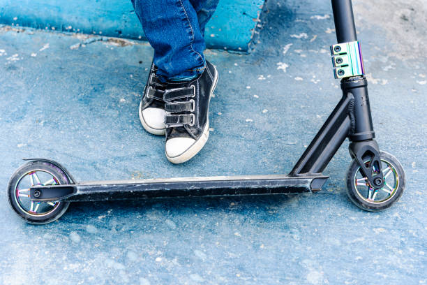 istock Rider boy legs close up in sneakers on stunt scooter 1600517408
