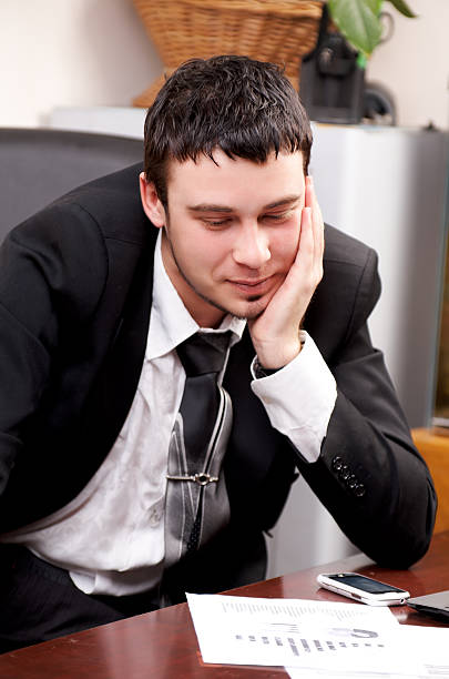 istock Young pensive businessman working in office 160052254