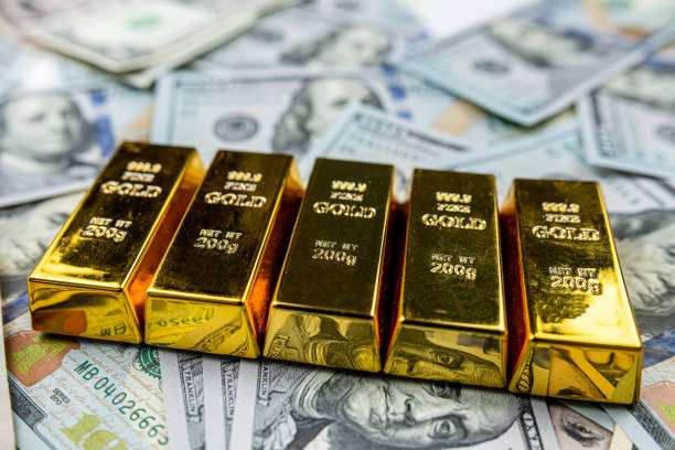 istock 100 dollar bill with gold bars as finance background 1600528470