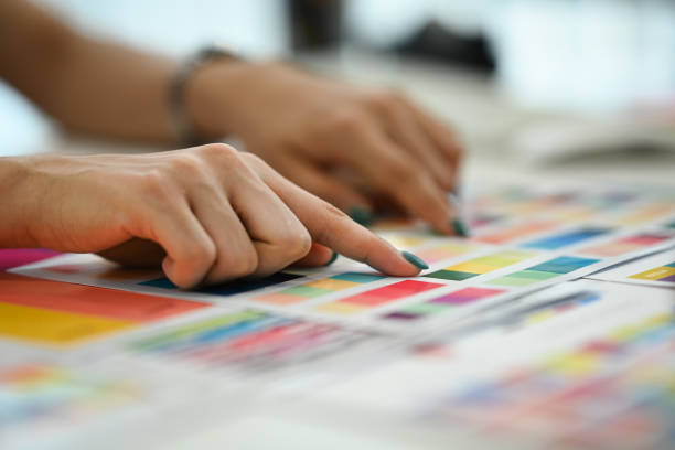 istock Closeup view female graphic designer working with color palette, choosing color samples for design project at modern office 1600528803