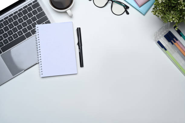 istock Blank notepad, laptop, glasses, coffee cup and plant on white office. Copy space for your text 1600529042