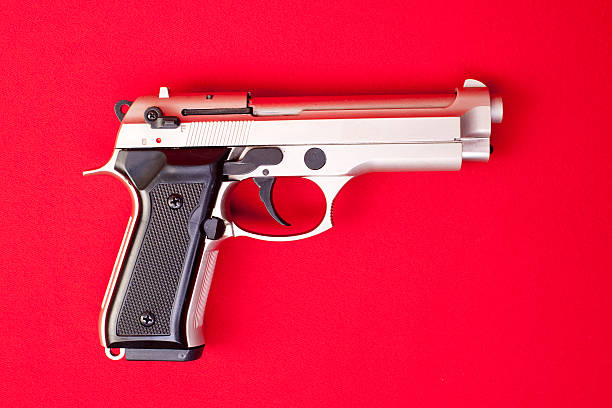 Semi-Auto Silver Gun On Red Background stock photo