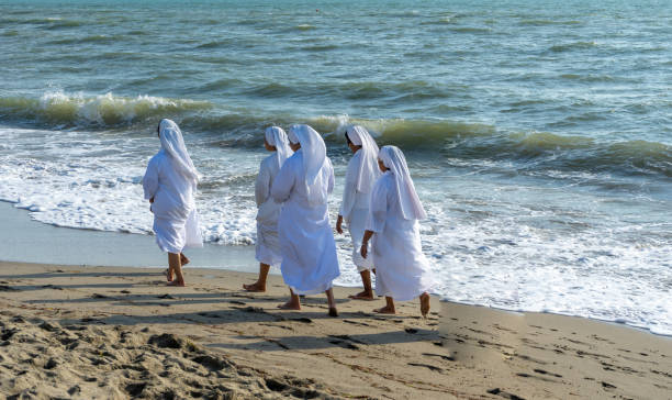 Nuns walk in the sand on the italia beach