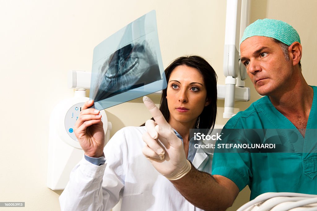 A doctor and an assistant dentist doctor consulting results Two Dentists examining x-ray Dentist Stock Photo