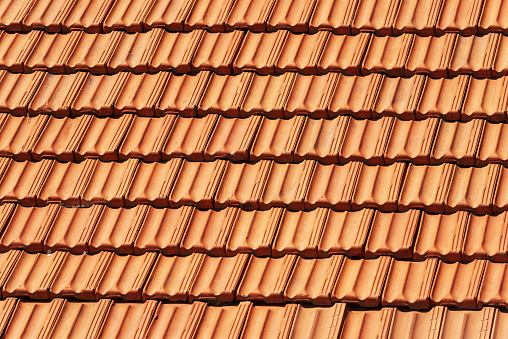 Closeup of a house roof with terracotta tiles (clay), full frame, photography. Liguria, Italy, Europe.