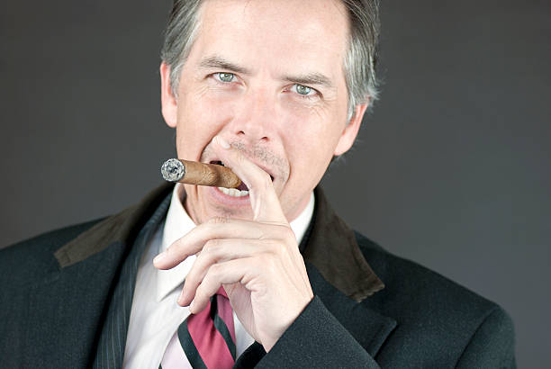istock Confident Businessman Smokes Cigar 160054150