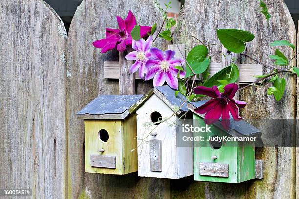 Tres Birdhouses En Old Wooden Valla Foto de stock y más banco de imágenes de Agujero - Agujero, Aire libre, Amarillo - Color