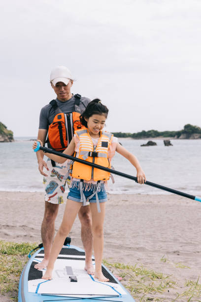 istock Dad patiently teaches daughter paddleboarding by the serene beach 1600558789