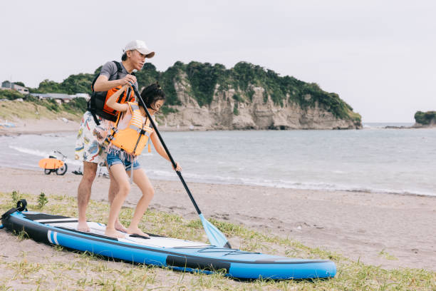 istock Dad patiently teaches daughter paddleboarding by the serene beach 1600558792
