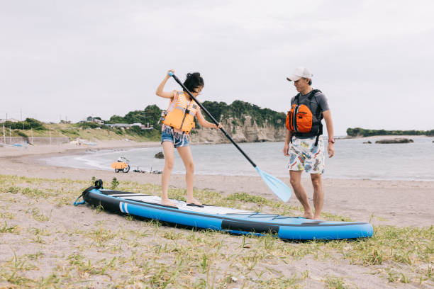 istock Father and daughter learn paddleboarding together by the sea 1600558849