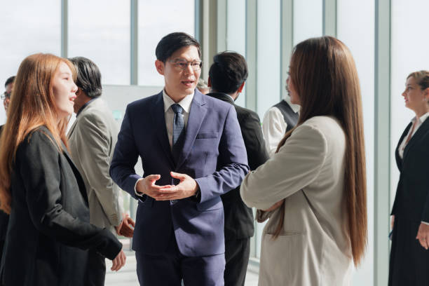 istock Confident Asian male leader telling diverse colleagues about new project 1600568363