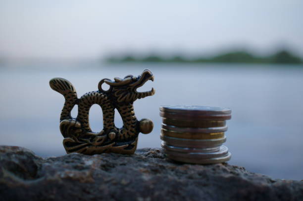 istock A Chinese dragon figurine and a stack of coins. 1600570677