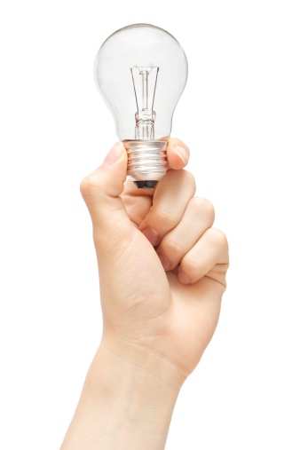 Light bulb held in hand isolated on white background.