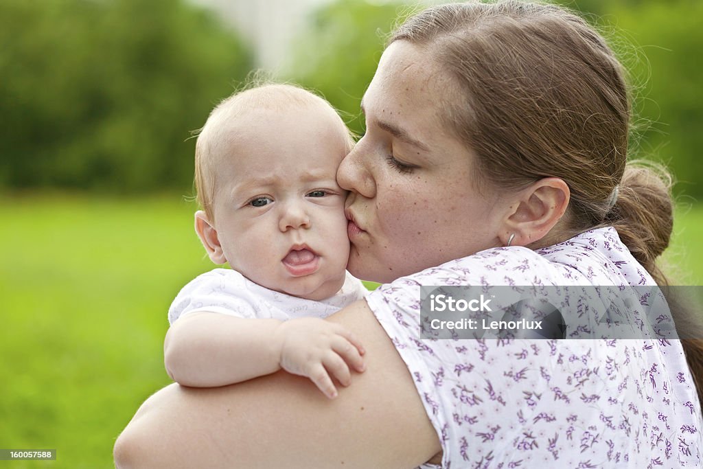 mum walks with the child Young mum walks with the child in city park Adult Stock Photo