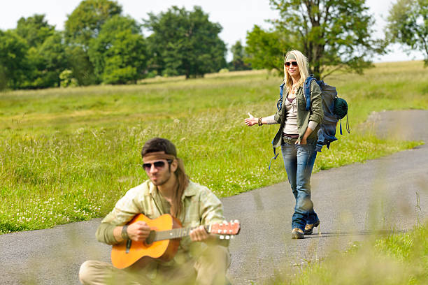 Hitch-hiking young couple backpack asphalt road stock photo