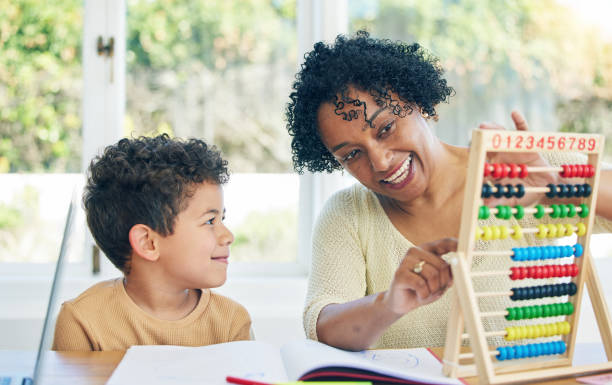 istock Education, grandmother or child learning math for kindergarten school homework or abacus at home. Smile, counting or happy senior woman working or helping a smart young boy student with development 1600587923