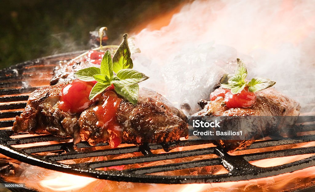Spessore di maiale alla griglia di carne su un barbecue, rosso marinata, fiamme - Foto stock royalty-free di Alla griglia