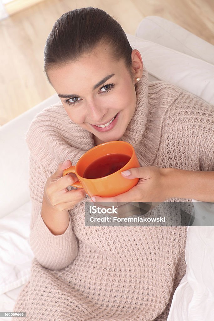 Donna, bere il tè in una tazza di arancione. - Foto stock royalty-free di 25-29 anni