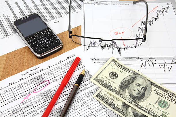 Business Business composition. Financial analysis - income statement, ink pen and US dollars money. smart phone telephone research tax stock pictures, royalty-free photos & images