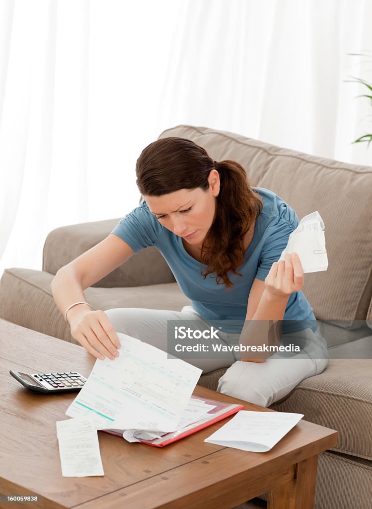 Pretty woman looking at her financial debts Pretty woman looking at her financial debts at home Adult Stock Photo