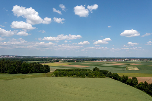 Idyllic, summer landscape with agricultural fields, forests, blue sky and cumulus clouds.