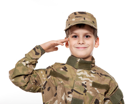 Saluting soldier. Young boy dressed like a soldier isolated on white